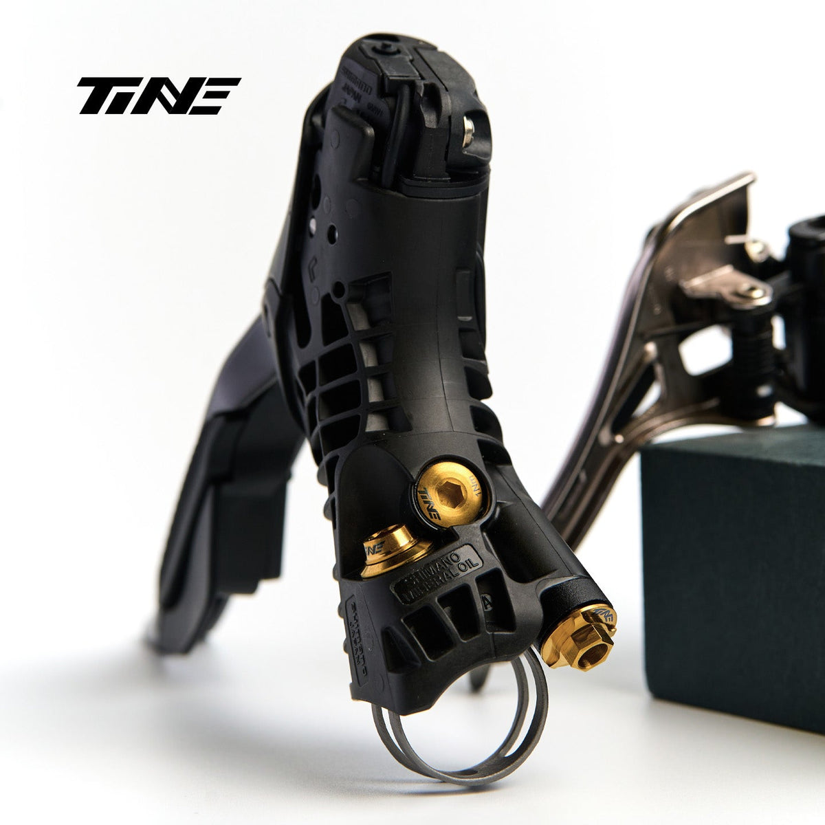 Tornillería de titanio TiNE dorada montada en una maneta Shimano Di2