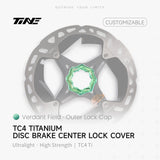 TiNE Tapa Center Lock Exterior de Titanio en acabado Verdant Field (verde) sobre un disco de freno