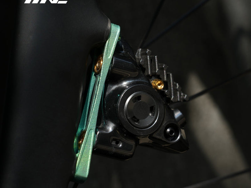 Adattatore per freno a disco TiNE verde montato su una pinza flat mount